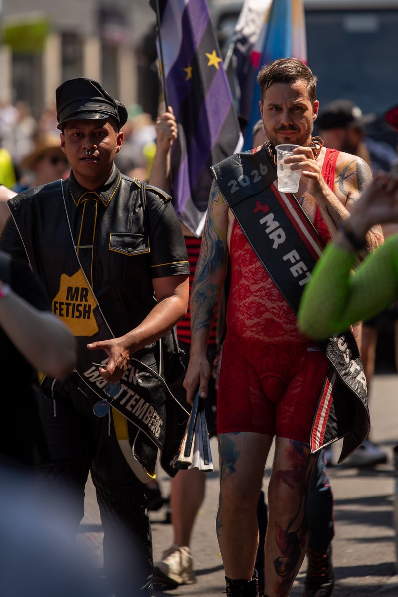 Teilnehmer mit Sch?pe l?ft durch die Parade, flankiert von Polizei und weiteren Pride-G?ten.