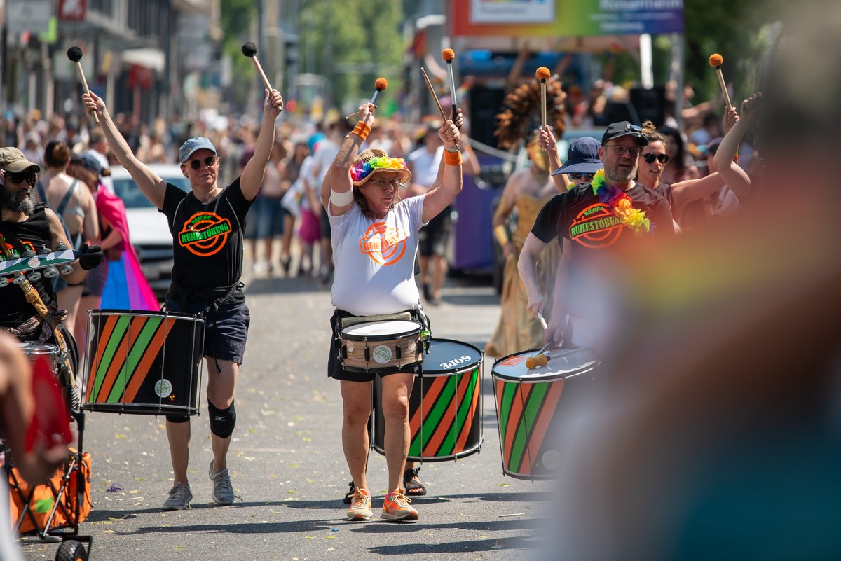 Gruppe mit Trommeln und Regenbogenb?dern begleitet die Parade musikalisch.