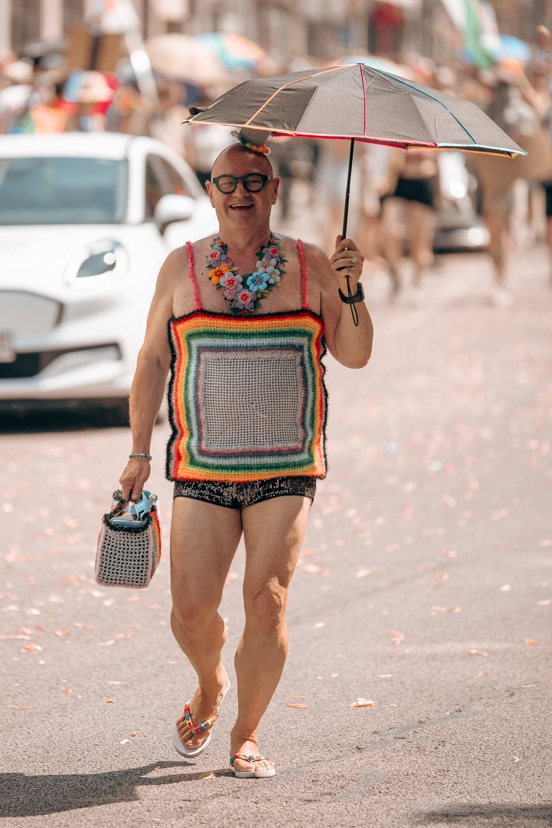 Person in buntem geh?eltem Outfit l?ft allein ?er die sonnige Stra?.