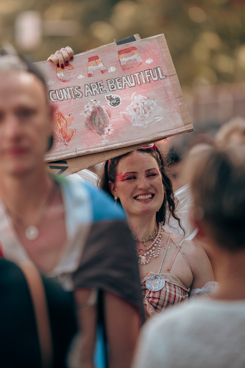 L?helnde Person h?t ein selbstgemaltes Schild mit roter Schrift ?er den Kopf.