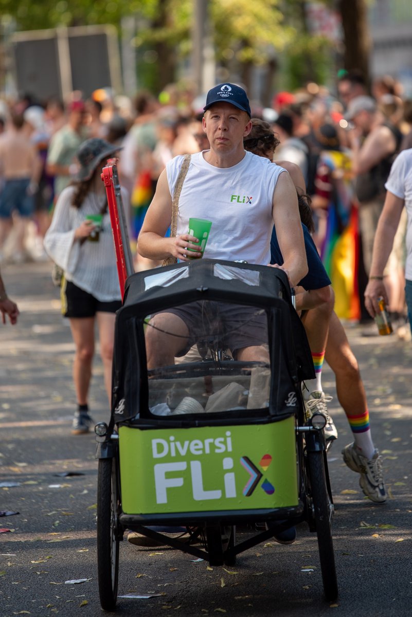 Fahrradrikscha mit dem Schriftzug ?DiversiFLIX? f?rt durch die Pride-Parade.