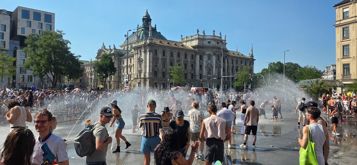 Menschen k?len sich im Brunnen am Karlsplatz nach der hei?n Pride-Parade ab.